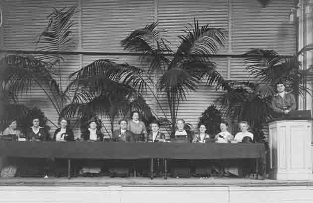 congreszaal met 12 deelneemster op het podium van het international congress of women 1915 