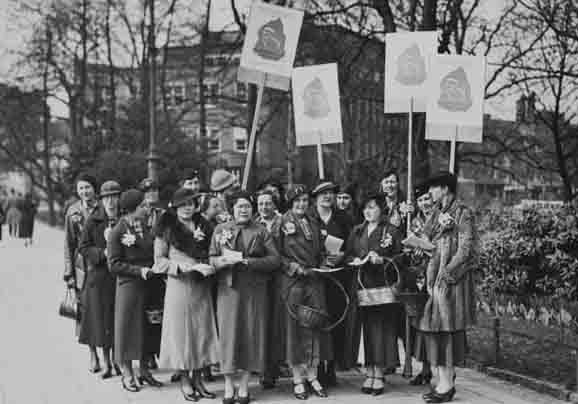 Vrouwen met protestborden met tekst 'Propaganda week van het comité ter bevordering van de waardering van vrouwenarbeid in het gezin en maatschappij 28 maart - 4 april'