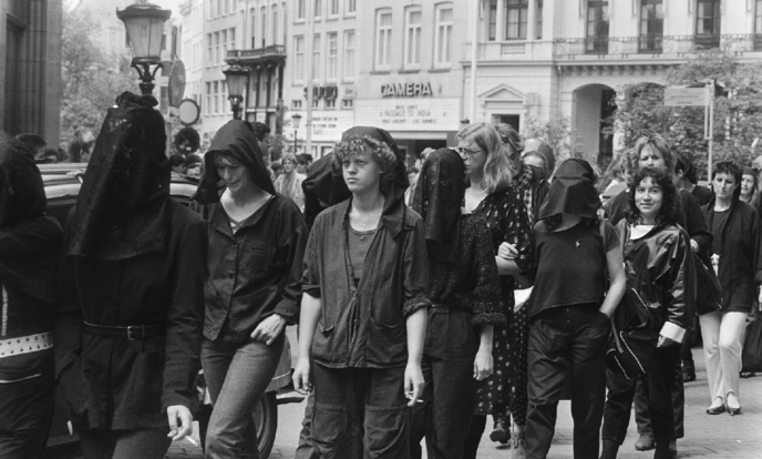 vrouwen lopen in een stoet in het zwart gekleed